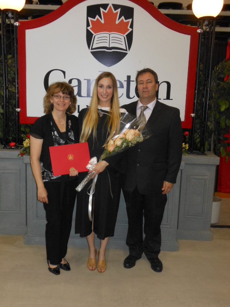 Deanna posing with her parents on her graduation day, celebrating a Bachelor of Arts, major in History from Carleton University in 2013